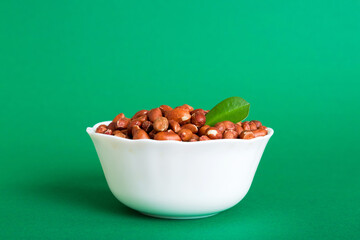 Fresh healthy peanuts in bowl on colored table background. Top view Healthy eating bertholletia concept. Super foods