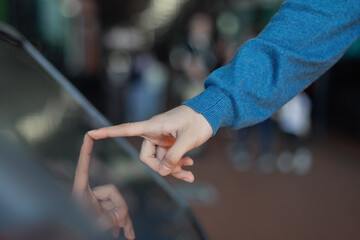 hand touch the interactive display on the self-service machine; check in for a flight; buy tickets...