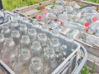 Used empty glass bottles stored in containers, selective focus.