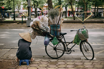 Fototapeta na wymiar traditional vietnamese street seller with hat and bicycle
