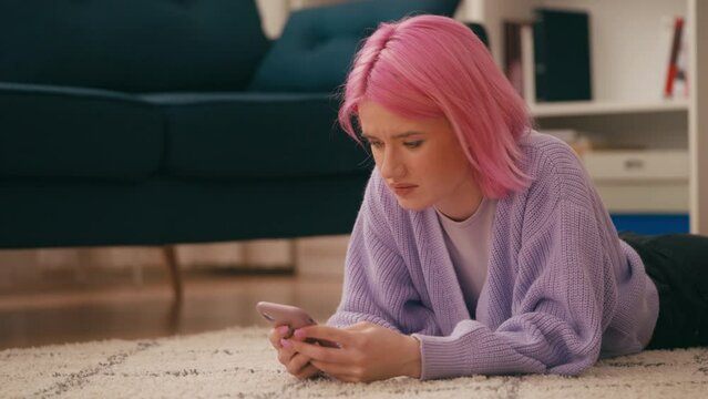 Sad young woman reading mean comments on phone, internet bullying, social media