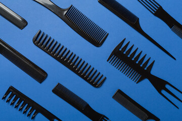 Professional combs and hairdresser tools on color background, top view