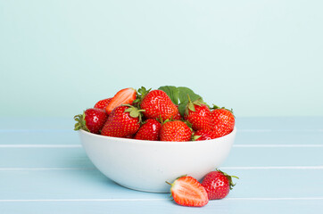 Fresh strawberries in bowl on wooden table