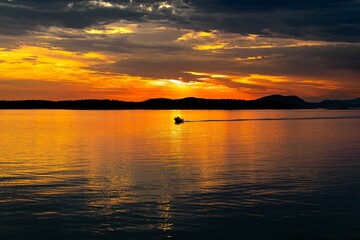 Beautiful sunset over the lake with a boat.