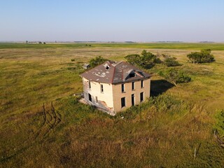 Bird's eye view of an abandoned farmhouse in the prairies of Saskatchewan, Canada