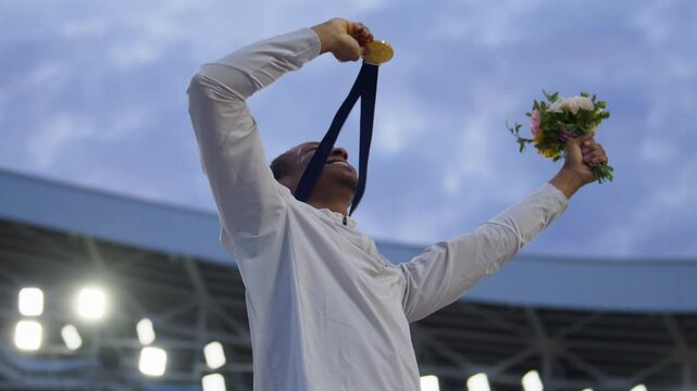 Young African Black male Athlete Celebrates a Win on a podium, receives a gold medal. Super slow motion, shot on RED cinema camera