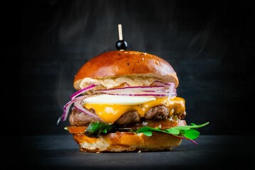 Selective focus shot of a juicy gourmet burger on a black background