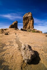 Fototapeta na wymiar Vertical shot of the Roque Nublo under a cloudy sky on a sunny day, Gran Canary, Spain