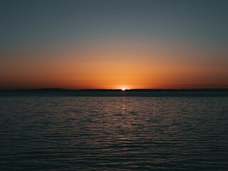 Naklejka na ściany i meble Beautiful shot of a calm lake during a sunset