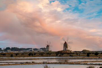 Sunset at the salt flats with the old windmill, saline dello Stagnone. Marsala, Trapani, Sicily, Italy, Europe.