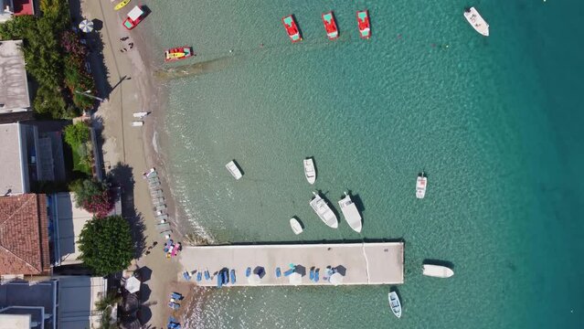 Aerial top view of a seafront with moored boats near the small town of Tolo in Argolida, Greece