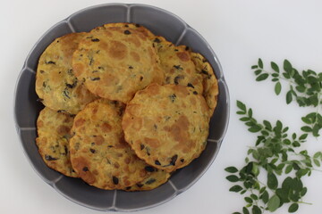 Deep fried Indian flat bread made of whole wheat flour, cooked lentils and moringa leaves and spices