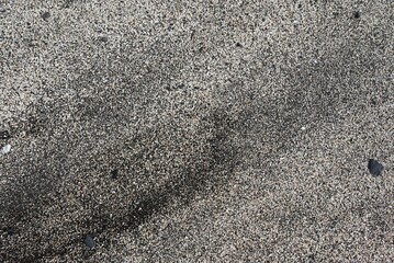 Close-up of gray sand on the beach on a sunny day © Stefko/Wirestock Creators
