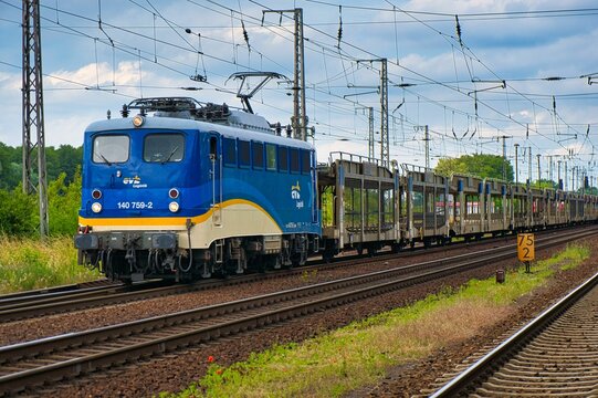 Locomotive of 140 class from evb Logistik pulls a cargo train with empty wagons through Priort