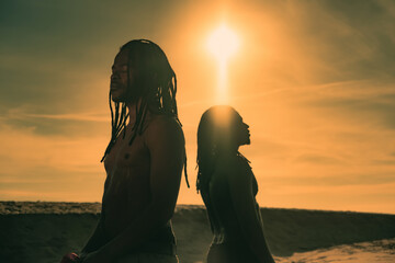Two friends African men wearing dreadlocks on ocean posing during beautiful sunset