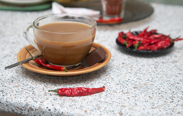 Close up cup of tea and a hot chili pepper on the table