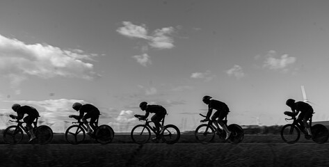Silhouettes of people riding bikes on a mountain trail
