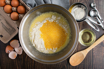 Buttermilk Cornbread Ingredients in a Mixing Bowl Viewed from Above: Coarse cornmeal, flour, eggs, and other ingredients for Southern cornbread