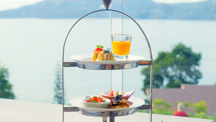 Snacks for cocktail hour in outdoor restaurant with sea view, served on white plate. Delicious appetizers in luxury dining setting, ideal for celebrations.