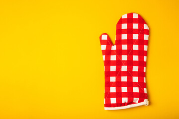 Kitchenware. Oven glove and potholder for hot dishes on a bright yellow background. close-up. Place for text. copy space.