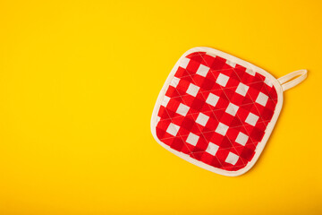 Kitchenware. Oven glove and potholder for hot dishes on a bright yellow background. close-up. Place for text. copy space.