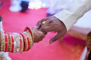Close-up shot of Indian bride and groom holding hands
