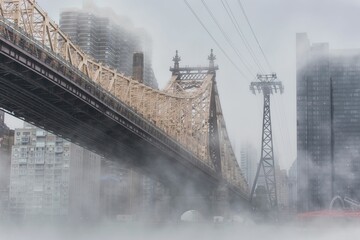 Scenic view of New York City with a bridge and modern buildings covered in fog