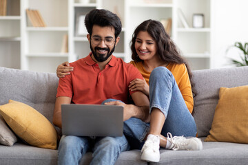 Portrait Of Romantic Indian Spouses Relaxing With Laptop At Home