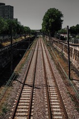 Fototapeta na wymiar Vertical shot of empty train tracks on a sunny day