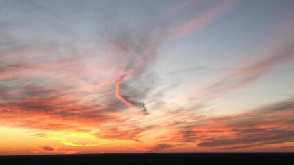 Fototapeta premium View of the orange-shaded sunset sky with cirrus clouds