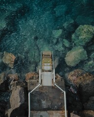 High-angle shot of a stairway down to a rocky beach