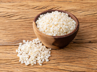 Dried canjica, hominy or white corn on a bowl over wooden table