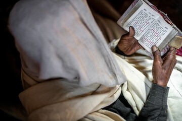 Old orthodox catholic Ethiopian woman reading the Bible