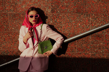 Fashionable elegant confident woman wearing trendy pink sunglasses, silk headscarf, suit blazer,...