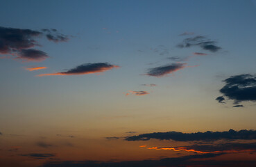 Evening sky background with dark clouds and golden winding lines on it