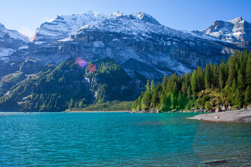 A stunning landscape featuring Lake Oeschinensee nestled in the Swiss Alps, showcasing its natural beauty and serenity.