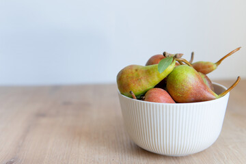 pears in a plate on a wooden background.