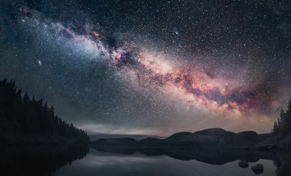 Beautiful shot of the Milky Way illuminating a dark night sky above a lake in Quebec, Canada