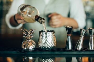 Closeup shot of a mixologist preparing cocktails at a bar