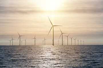 Offshore Windmill farm. windmills isolated at sea on a beautiful bright day Netherlands. green energy Flevoland global warming renewable enrgy with windmills - obrazy, fototapety, plakaty