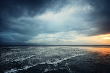 View of beautiful seascape at sunset, sea waves moving towards shore under gloomy and cloudy sky © 赵天旭/Wirestock Creators