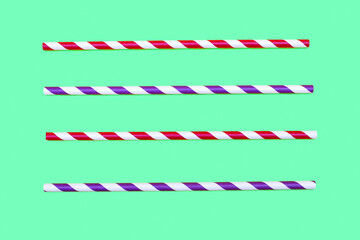 Obraz premium Four multi-colored striped drinking straws are arranged parallel in a row on a green background. Paper eco-friendly drinking accessories in the form of striped straws