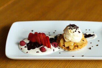 Closeup shot of a cookie with an ice cream topping and berries at a restaurant