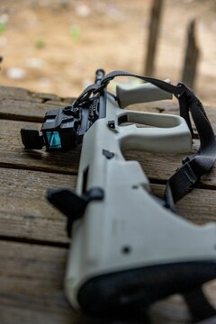 Vertical shot of a toy gun on a wooden table outside for practicing
