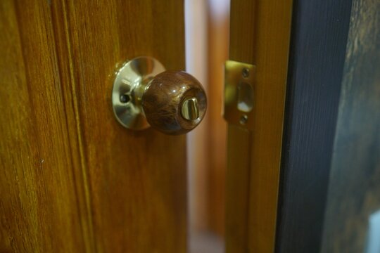 Closeup Shot Of A Round Metallic Handle On A Wooden Door