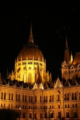 Fototapeta na wymiar Vertical shot of the illuminated Parliament building at night in Budapest, Hungary