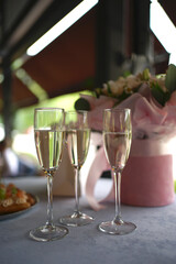 Three glasses of champagne on the buffet table.