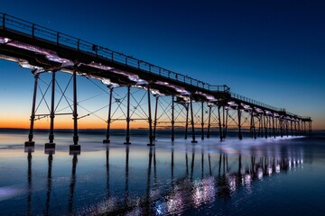 Low-angle view of a beautiful bridge above the sea at sunset in Saltburn, England