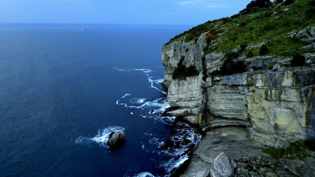 Drone footage of green cliffs coastline by the sea shore