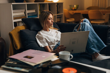 A blond woman enjoys listening to records alone.